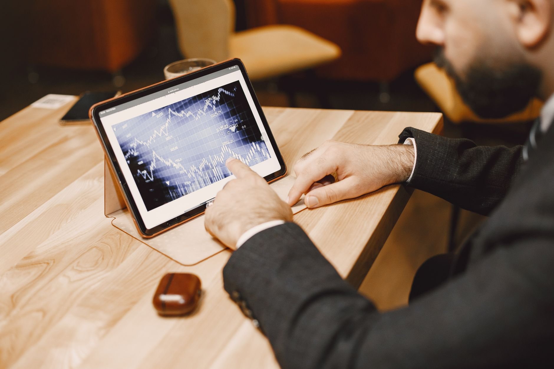 Business professional reviewing digital asset portfolio on tablet in modern office
